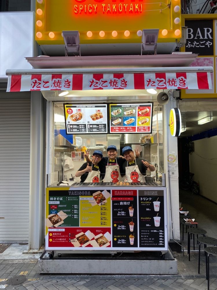 Fazendo takoyaki e tacos em Dotonbori. Por favor, forneça um atendimento ao cliente que faça os turistas estrangeiros sorrirem.